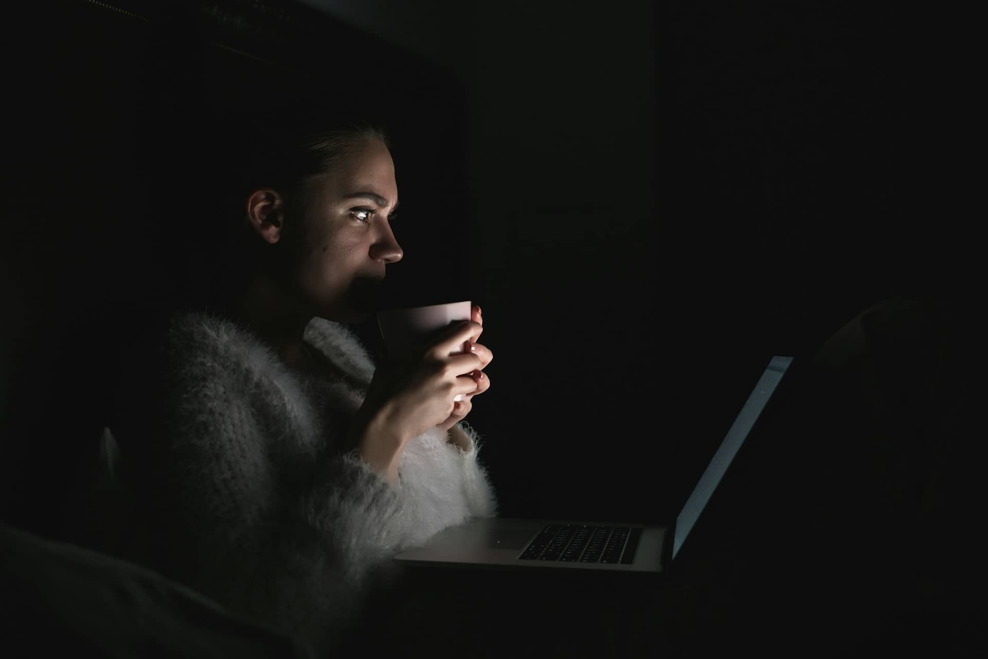A writer at a desk with a laptop and notes